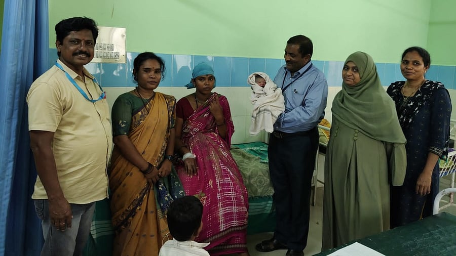 Block Election officer Venkatesh Ramachandra holds the child that was born at a polling booth in Korlagundi village, in Kurugodu taluk, Ballari district on Wednesday. photo by special arrangements. Credit: Special arrangement