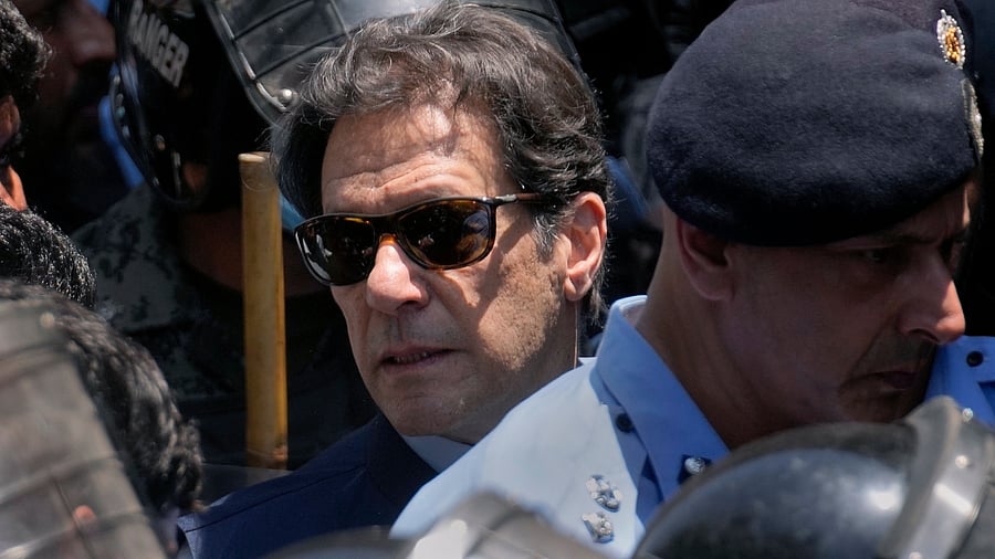 Pakistan's former Prime Minister Imran Khan, center, is escorted by police officers as he arrives to appear in a court, in Islamabad, Pakistan, Friday, May 12, 2023. Credit: AP/PTI Photo