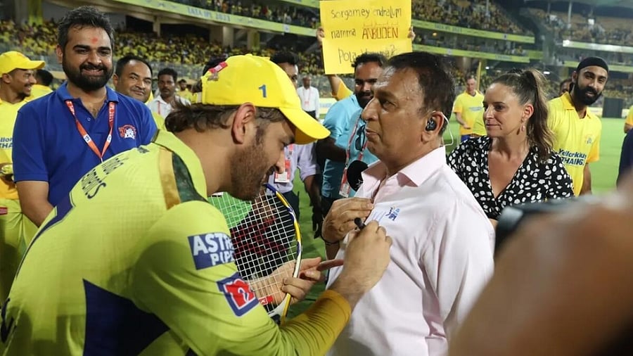 MS Dhoni signing Sunil Gavaskar's shirt. Credit: IANS Photo