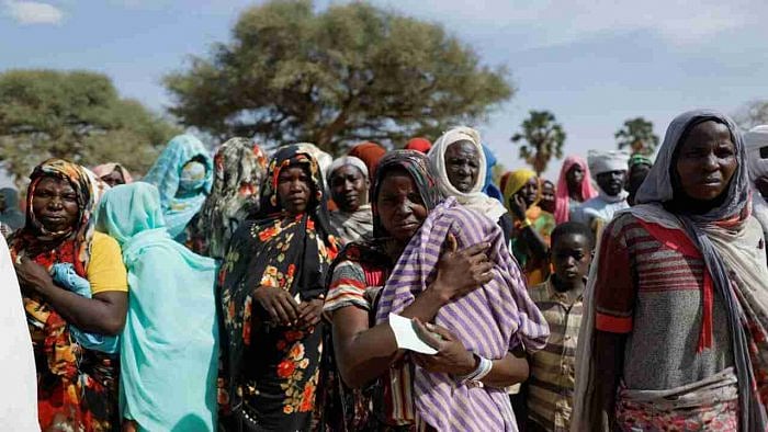 Sudanese refugees, who fled the country, wait to receive food supplies from a Turkish aid group (IHH) near the border between Sudan and Chad in Koufroun, Chad May 7, 2023. Credit: Reuters Photo
