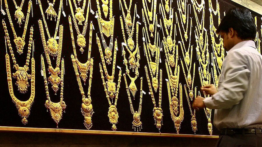 A salesman arranges a gold necklace inside a gold jewellery shop in the southern Indian city of Kochi. Credit: Reuters Photo