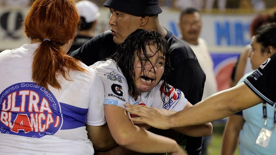 - A woman is held by other as she cries following a stampede during a football match between Alianza and FAS at Cuscatlan stadium in San Salvador. Credit: AFP Photo