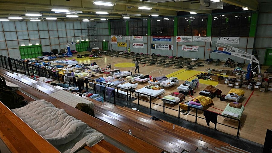 Local residents rest in an emergency accomodated sports hall, after being evacuated from their homes following deadly floodwaters in the Emilia-Romagna region, in Castel Bolognese, near Faenza, on May 20, 2023. Credit: AFP Photo