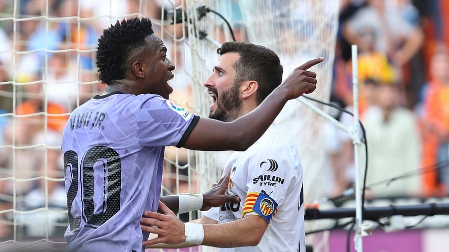 Real Madrid's Vinicius Junior, left, confronts Valencia fans in front of Valencia's Jose Luis Gaya during a Spanish La Liga soccer match between Valencia and Real Madrid, at the Mestalla stadium in Valencia, Spain, Sunday, May 21, 2023. Credit: AP/PTI Photo
