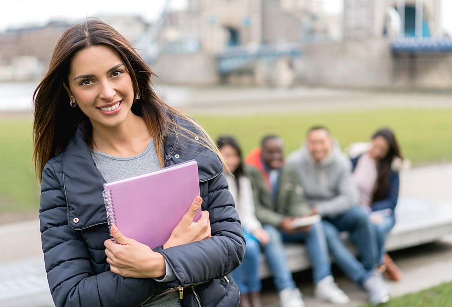 Happy female student outdoors looking at the camera smilingStudents at campus
