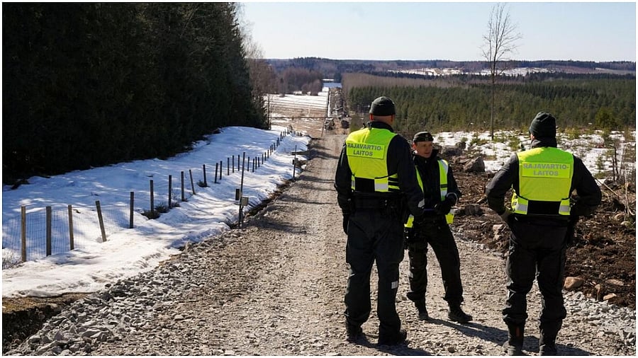 Finnish border guards stand near border fence with Russia in Pelkola, Finland April 14, 2023.