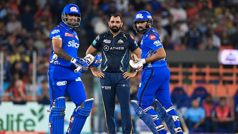 Gujarat Titans' Mohammed Shami (C) watches as Mumbai Indians' Rohit Sharma (R) with teammate Suryakumar Yadav takes a run during the Indian Premier League (IPL) Twenty20 second qualifier cricket match between Mumbai Indians and Gujarat Titans at the Narendra Modi Stadium in Ahmedabad. Credit: AFP Photo