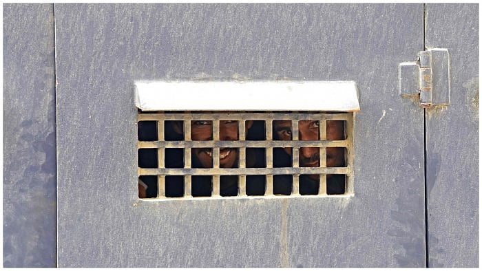 Indian fishermen look from a prison van. Credit: AFP Photo  