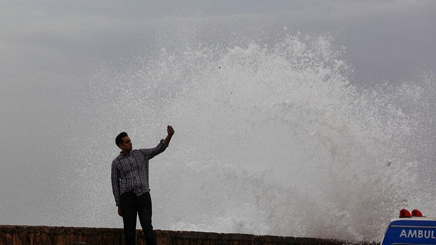 A man takes a selfie beside a rising wave, before the arrival of the cyclonic storm, Biparjoy, over the Arabian Sea, at Clifton beach, in Karachi, Pakistan June 13, 2023. Credit: Reuters Photo
