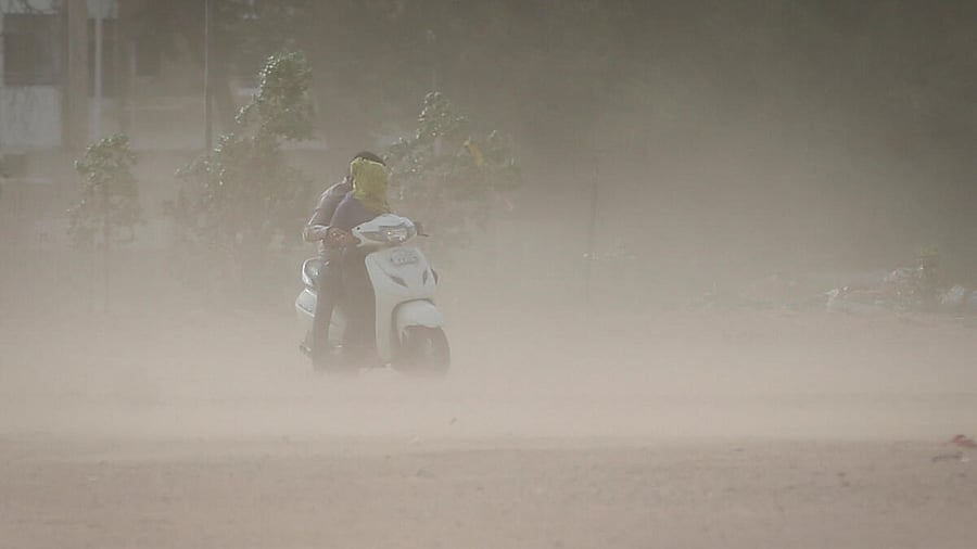 A couple rides a scooter amid dust due to strong wind, before the arrival of cyclonic storm Biparjoy, in Ahmedabad, India, June 15, 2023. Credit: Reuters Photo