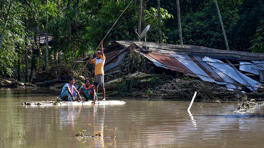 Villagers row a makeshift raft to move across a flooded locality at Kanduguri village, in Bajali district of Assam, Friday, June 23, 2023. Credit: PTI Photo
