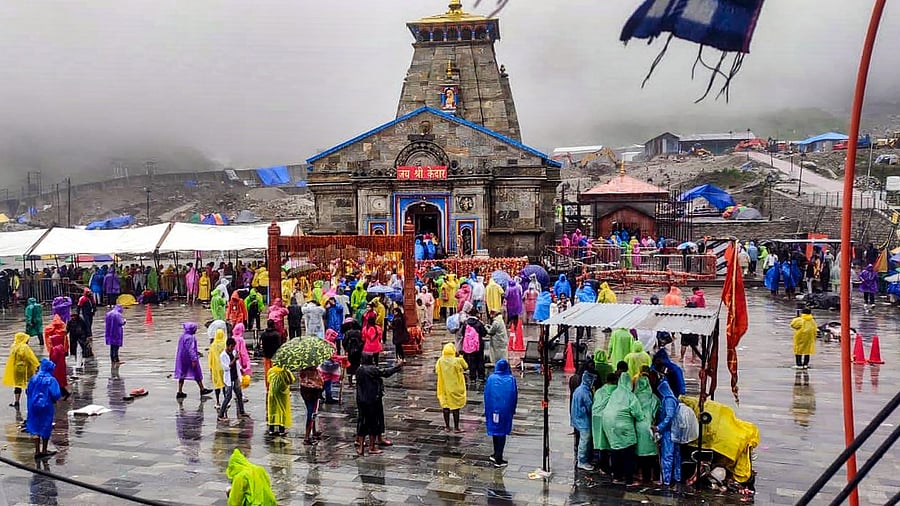 Devotees wearing raincoats visit the Kedarnath temple amid rain, in Rudraprayag district. Credit: PTI Photo