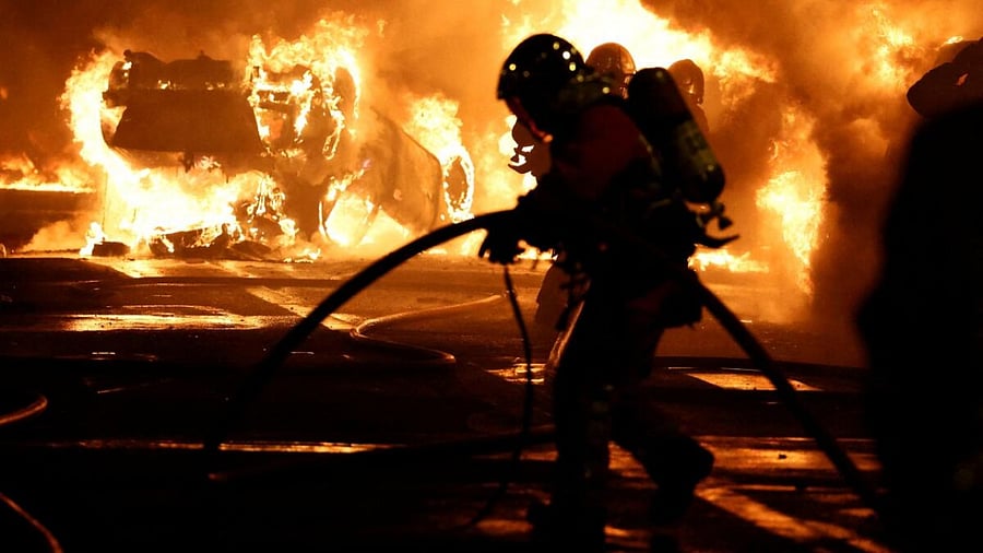 Firefighters extinguish burning vehicles during clashes between protesters and police, after the death of Nahel, a 17-year-old teenager killed by a French police officer during a traffic stop, in Nanterre, Paris suburb, France, June 28, 2023. Credit: Reuters Photo