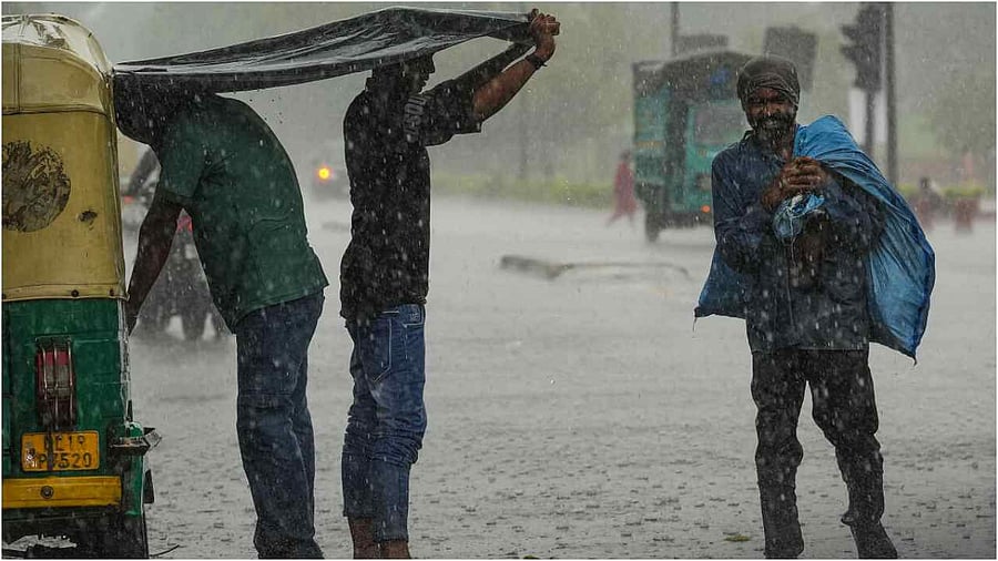 New Delhi: People walk amid monsoon rains, in New Delhi, Friday, June 30, 2023. Credit: PTI Photo
