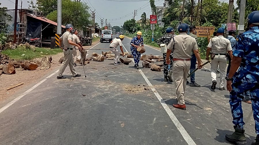 Security forces personnel clear a road that was blocked by miscreants a day after a violent clash broke out between two groups over nomination filing for panchayat polls, in South 24 Parganas district, Wednesday, June 14, 2023. Credit: PTI Photo