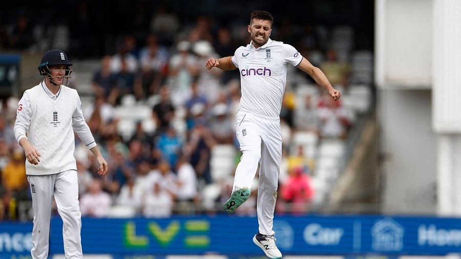England's Mark Wood celebrates after taking the wicket of Australia's Usman Khawaja. Credit: Reuters Photo