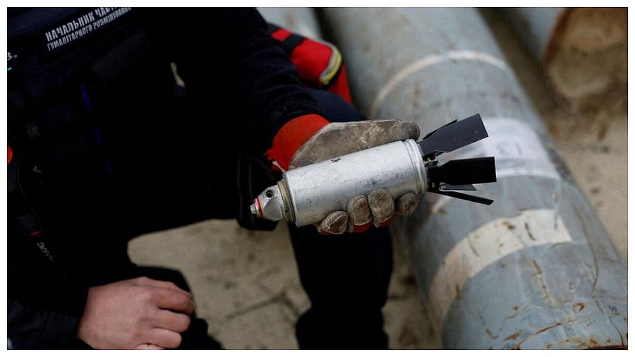 Ukrainian military serviceman Igor Ovcharruck holds a defused cluster bomb from an MSLR missile. Credit: Reuters File Photo