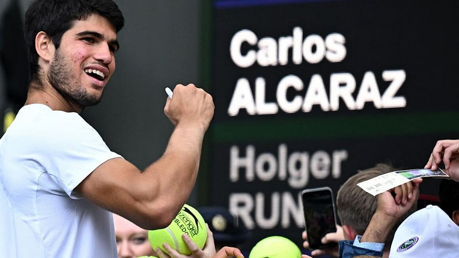 Spain's Carlos Alcaraz signs autographs for the spectators after winning his quarter final match against Denmark's Holger Rune. Credit: REUTERS