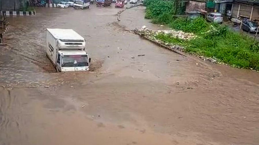 Vehicles move through the waterlogged National Highway 27 following monsoon rains, at Jorabat near Guwahati. Credit: PTI Photo