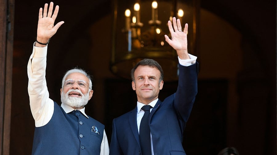 France's President Emmanuel Macron and India's Prime Minister Narendra Modi wave to the press prior to attending a meeting at The Ministry of Foreign Affairs in Paris. Credit: Reuters Photo