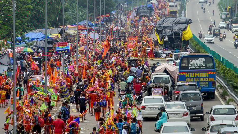Lord Shiva devotees or 'Kanwariyas' carrying holy water from the Ganga river during their pilgrimage. Credit: PTI Photo