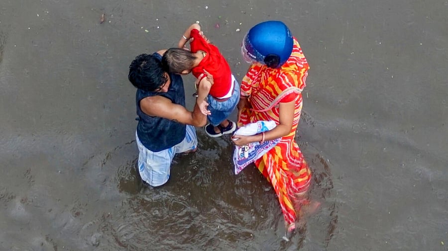 Locals wade through a waterlogged road amid monsoon rainfall, in Jaipur. Credit: PTI Photo