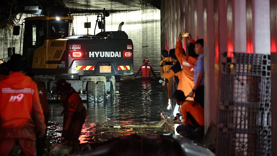 Rescue workers take part in a search and rescue operation inside an underpass that has been submerged by a flooded river caused by torrential rain in Cheongju, South Korea. Credit: Yonhap via Reuters Photo