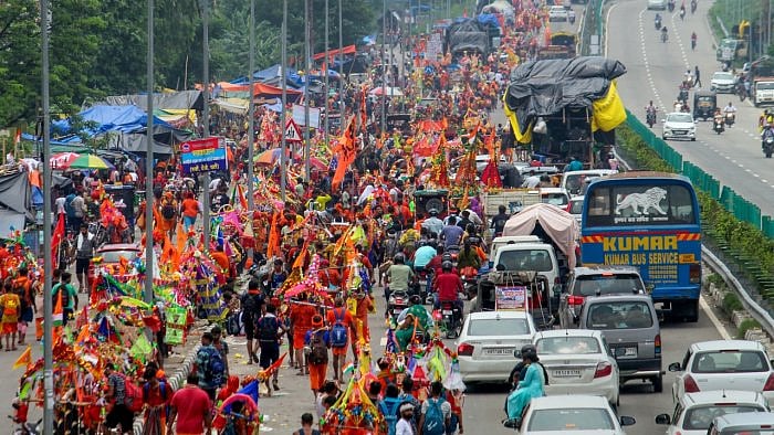 Lord Shiva devotees or 'Kanwariyas' carrying holy water from the Ganga river during their pilgrimage. Credit: PTI Photo  