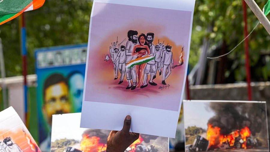 A Tamil Nadu Youth Congress supporter holds a placard during a protest against the central government regarding the ongoing ethnic violence in Manipur, in Chennai, Friday, July 21, 2023. Credit: PTI Photo