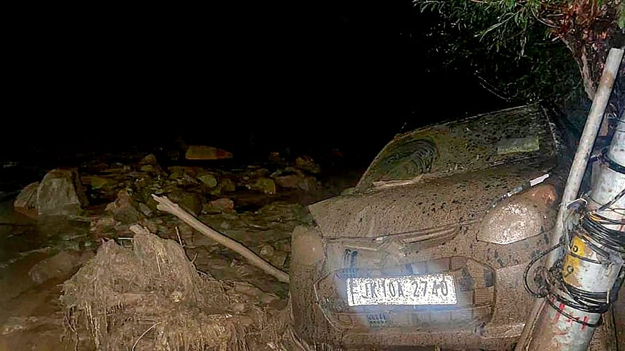 A damaged vehicle lies covered in silt and debris after cloudburst, in Leh district. Credit: PTI Photo