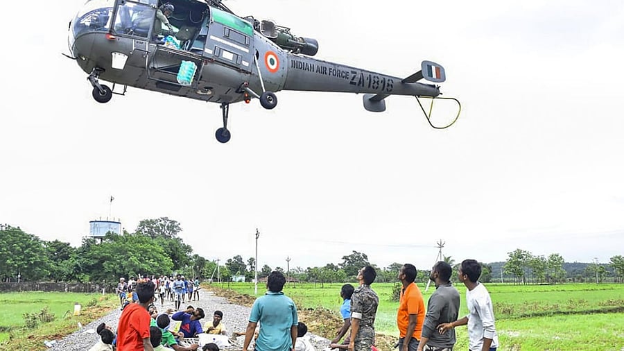 An Indian Air Force helicopter drops relief packets for flood-hit people in Telangana. Credit: PTI Photo