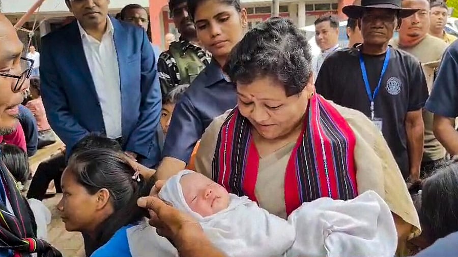 Manipur Governor Anusuiya Uikey with a child who was born in a relief camp during her visit to violence-hit Churachandpur, Saturday, July 29, 2023. Credit: PTI Photo