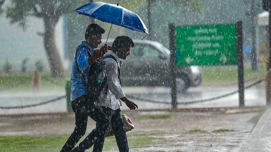 Pedestrians amid monsoon rain in New Delhi, Friday, July 28, 2023. Credit: PTI Photo