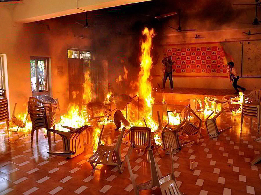  TRS activists set affire chairs at the TDP office in Nalgonda on Tuesday during a protest over the issue of power generation in Srisailam Project. PTI Photo