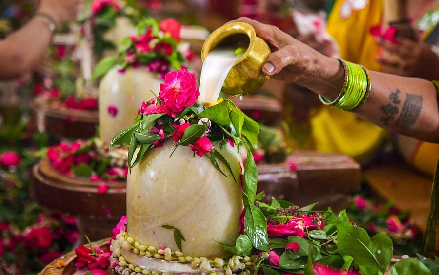 Hindu devotees perform 'Abhishekam' to Lord Shiva in the holy month of 'Shravan' at a temple, in Allahabad on Monday, August 13, 2018. (PTI Photo)