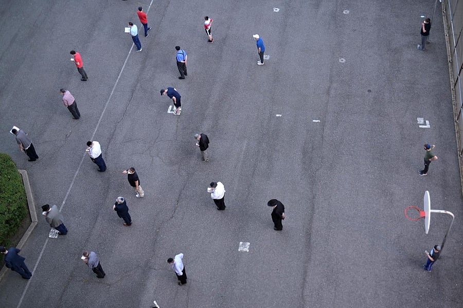  A group of Jewish men gather in the Basketball Court on the Lower East Side to pray while Temples remain closed due to the coronavirus in New York City. Credit/AFP Photo