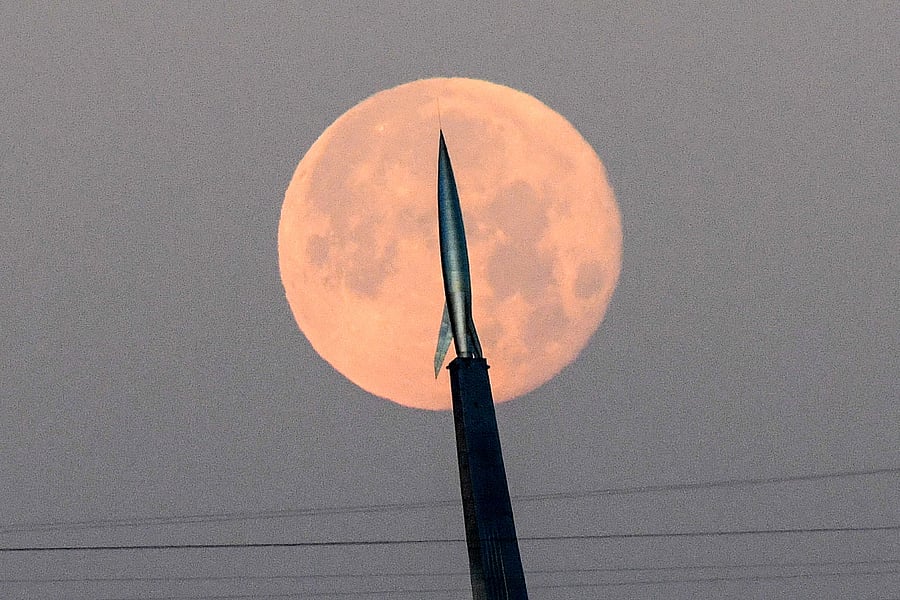 The full moon is pictured behind the model of a rocket atop the National cosmonaut museum in Moscow. Credits: AFP Photo
