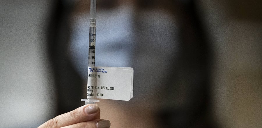 A healthcare worker displays a Covid-19 vaccine at the Portland Veterans Affairs Medical Center in Portland, Oregon. The first rounds of Pfizer's vaccine were administered in Oregon. Credit: AFP
