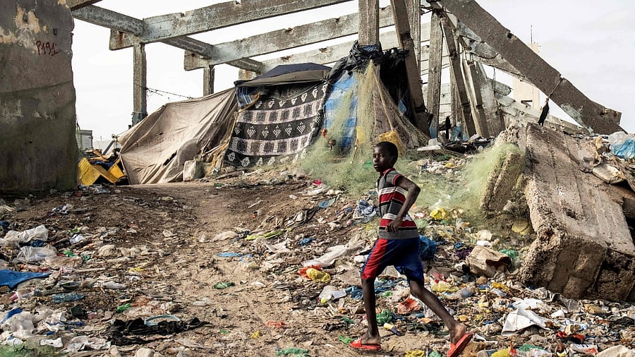 A young boy runs through a Fish Market destroyed by the rising seas in the seaside fishing neighbourhood of Guet N’Dar in Saint Louis. Credit: AFP Photo