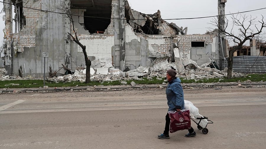 A local resident walks past a building destroyed during Ukraine-Russia conflict in the southern port city of Mariupol. Credit: Reuters photo