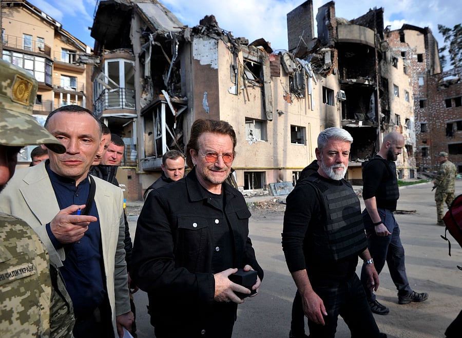 Bono (C) (Paul David Hewson), activist and front man of the Irish rock band U2 inspects the damage to a residential area in the Ukrainian town of Irpin, near Kyiv. Credit: AFP Photo
