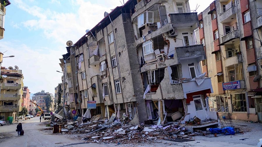 A local resident walks past a destroyed building in Hatay, on February 11, 2023, after a 7.8-magnitude earthquake struck the country's southeast. Credit: AFP Photo