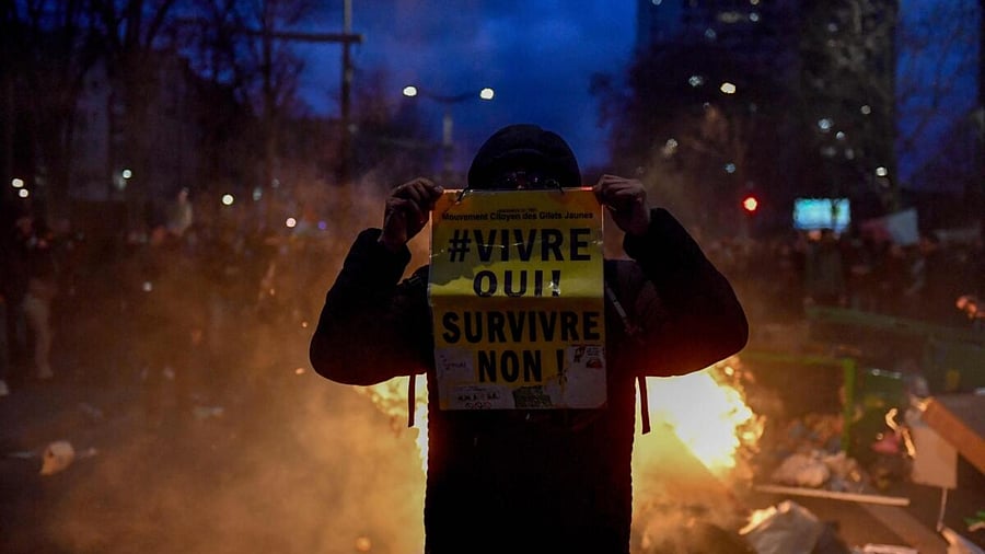 A protesters holds a placard that reads "Live Yes! Survive No!" during a demonstration near Place d'Italie in Paris. Credit: AFP Photo