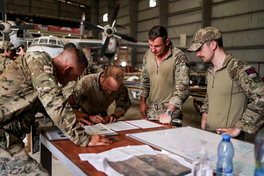 Royal Marines and Duke of Lancaster's Regiment personnel attend a meeting during the evacuation of British citizens, at Wadi Seidna airport, Sudan. Credit: Reuters Photo