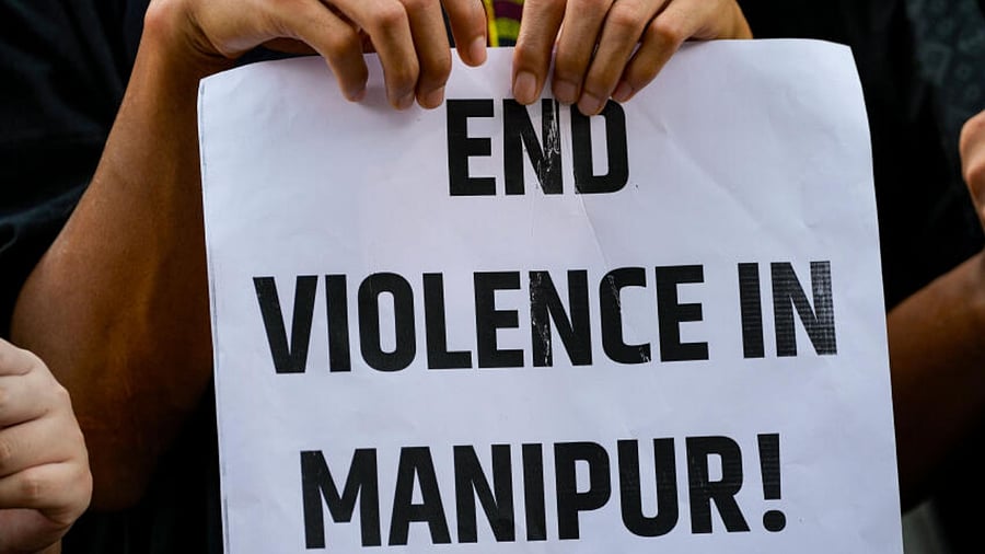 A protester holds a placard during a protest against the ongoing ethnic violence in Manipur state, in New Delhi, Friday, July 21, 2023. Credit: PTI Photo