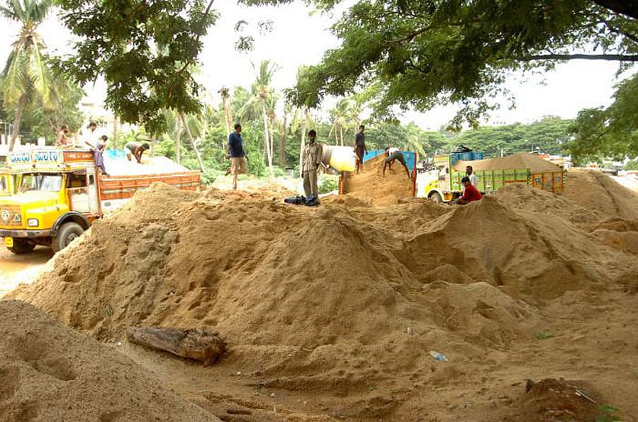 Trucks unload sand at a makeshift stock yard in Bengaluru.