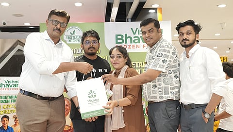 Kuruvilla Mathew, business head of Vishnu Bhavan Frozen Foods, presents a Vishnu Bhavan Heritage Hamper to customers at the launch of the brand's frozen food range at Pothy's, Kochi. 