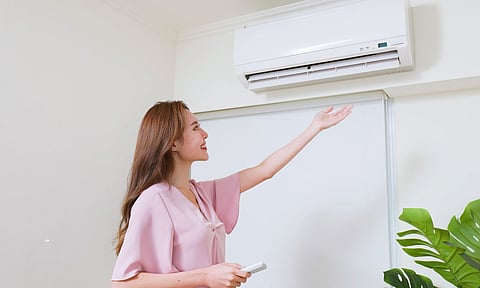 women standing Infront of a air conditioner 