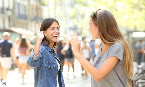 Friends meeting and greeting in the street