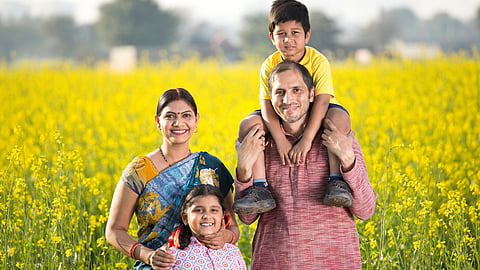 Indian Family smiling in front of a paddy field